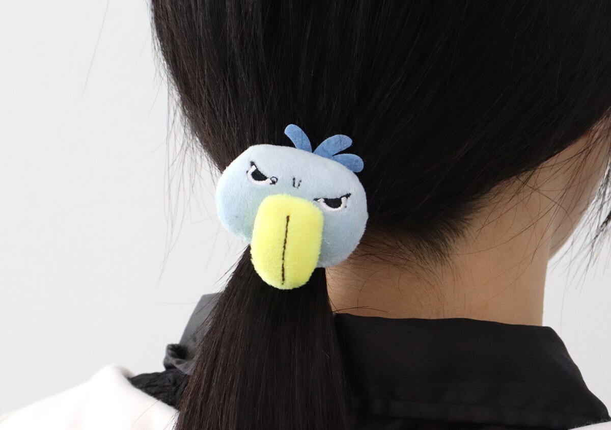 女性の黒髪にペンギンの顔のヘアポニーをつけた後ろ姿
