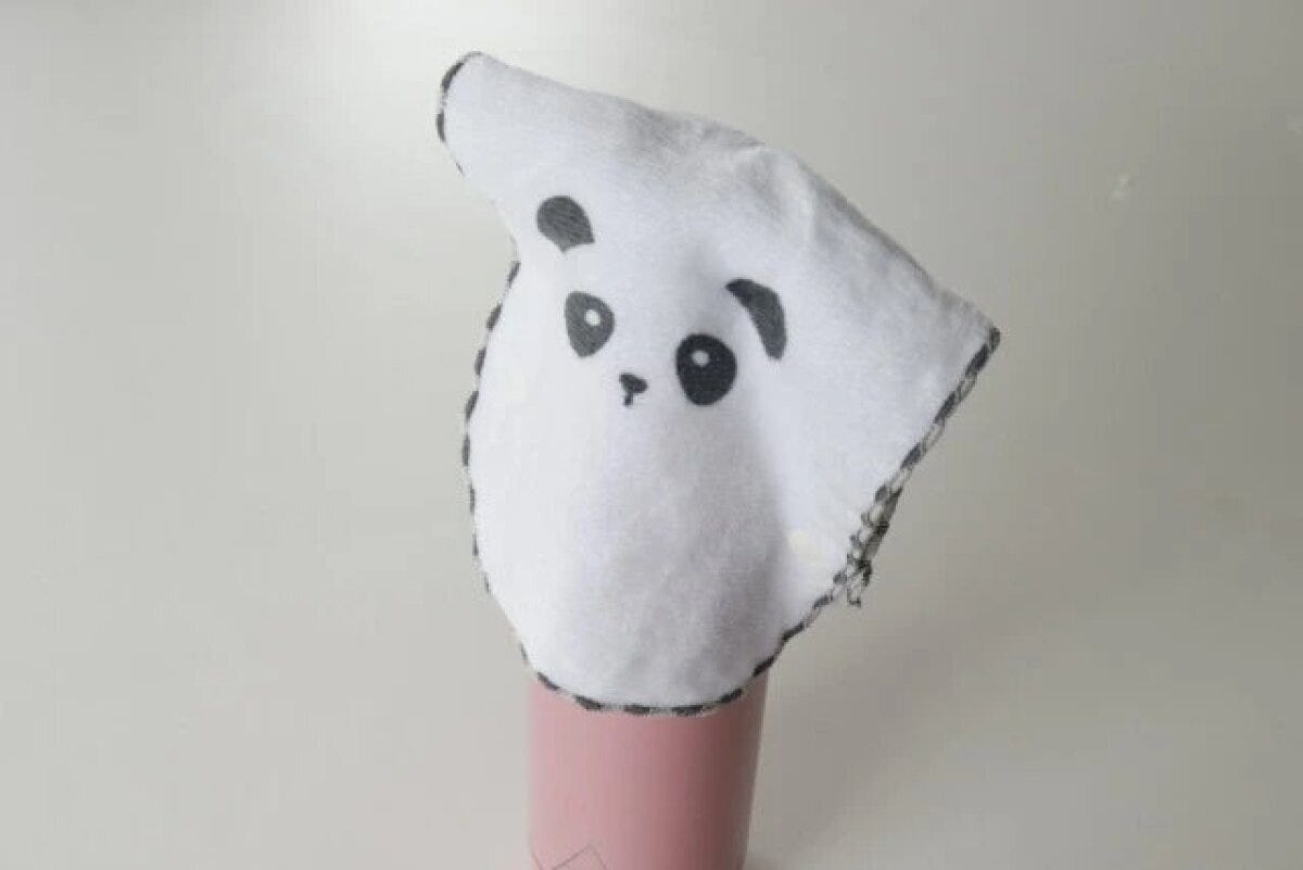 パンダ柄のカブセルハンカチがピンクの水筒にかぶせられている パンダ柄のカブセルハンカチがピンクの水筒にかぶせられている