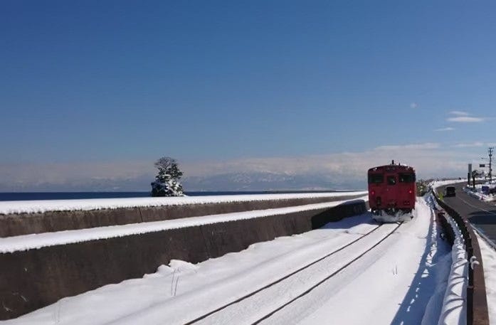 雨晴海岸から望む富山湾と立山連峰の雪景色。タイミングが合えばJR氷見線の列車も一緒に見ることができます(2022年2月撮影)