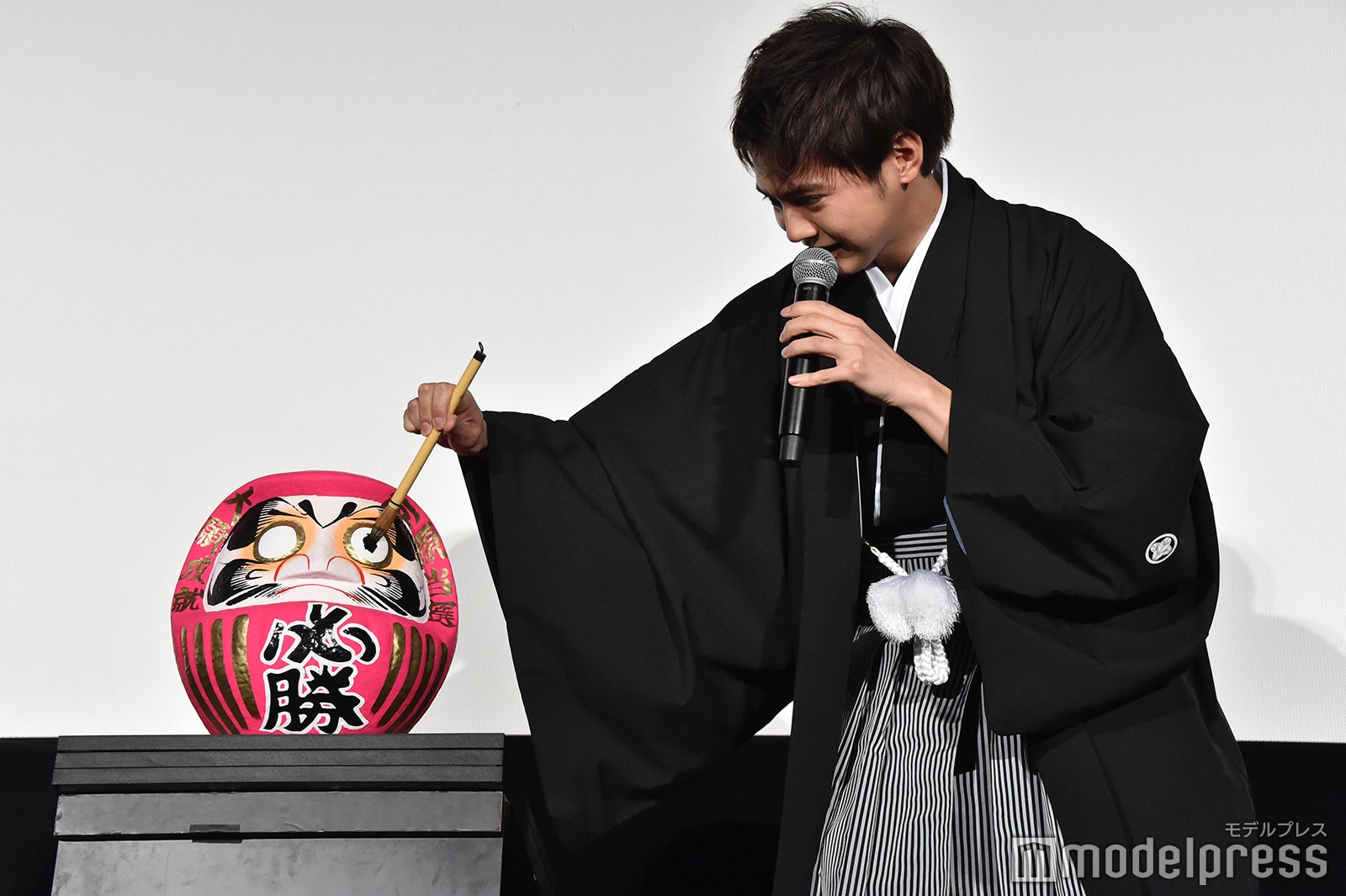 慎重にだるまの目入れをする片寄涼太 （C）モデルプレス