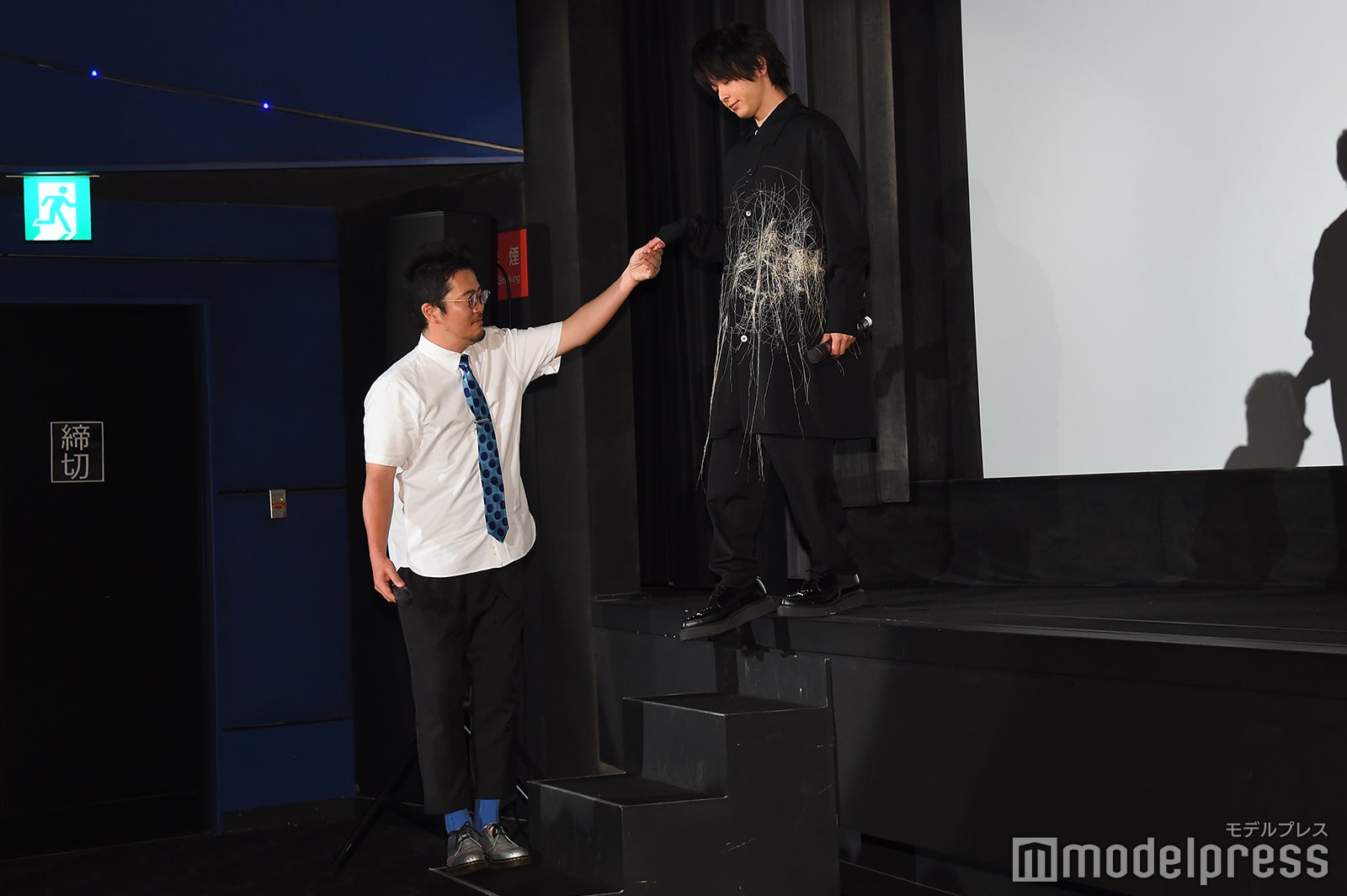 中野量太監督（左）から手を差し出され満足した様子で手をとる中村倫也（右）／（C）モデルプレス