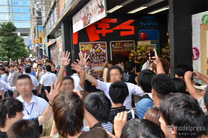 劇場の裏口に殺到するファンを制止するスタッフ