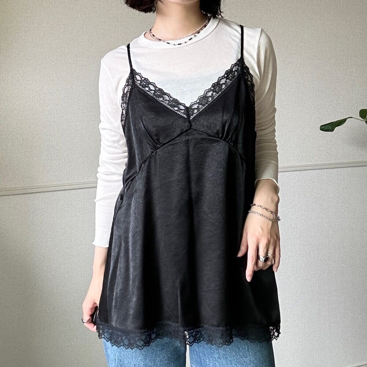 白いロンTとデニムに黒いサテンキャミソールを重ね着した女性の全身