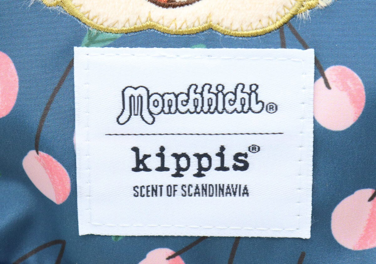紺色ポーチのモンチッチとkippisのロゴタグのアップ 紺色ポーチのモンチッチとkippisのロゴタグのアップ