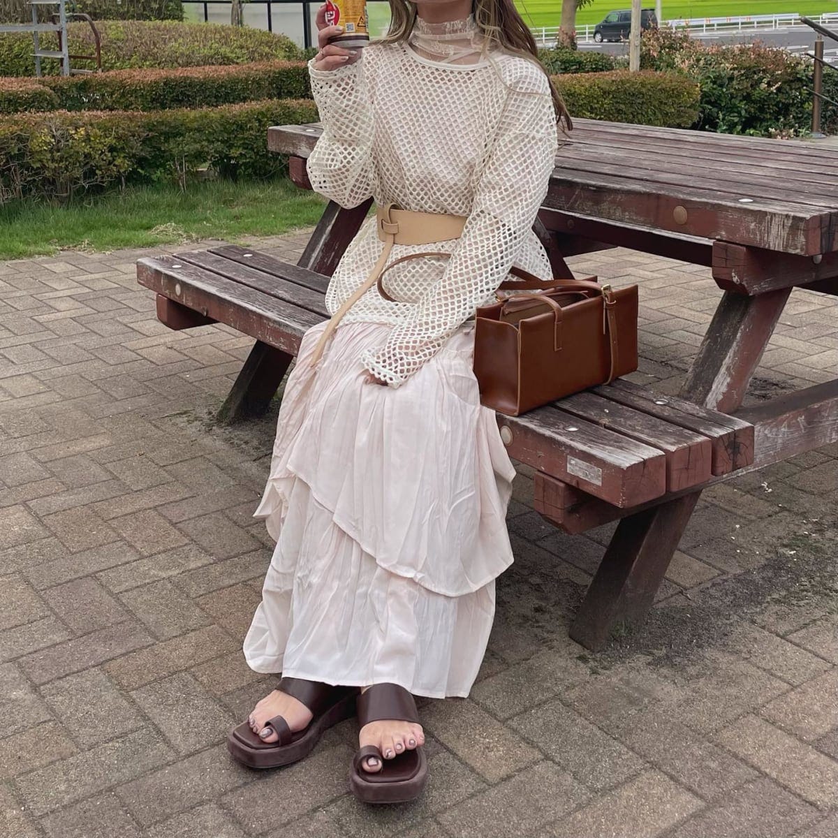 ホワイトメッシュトップスにスカートを合わせたコーデの女性