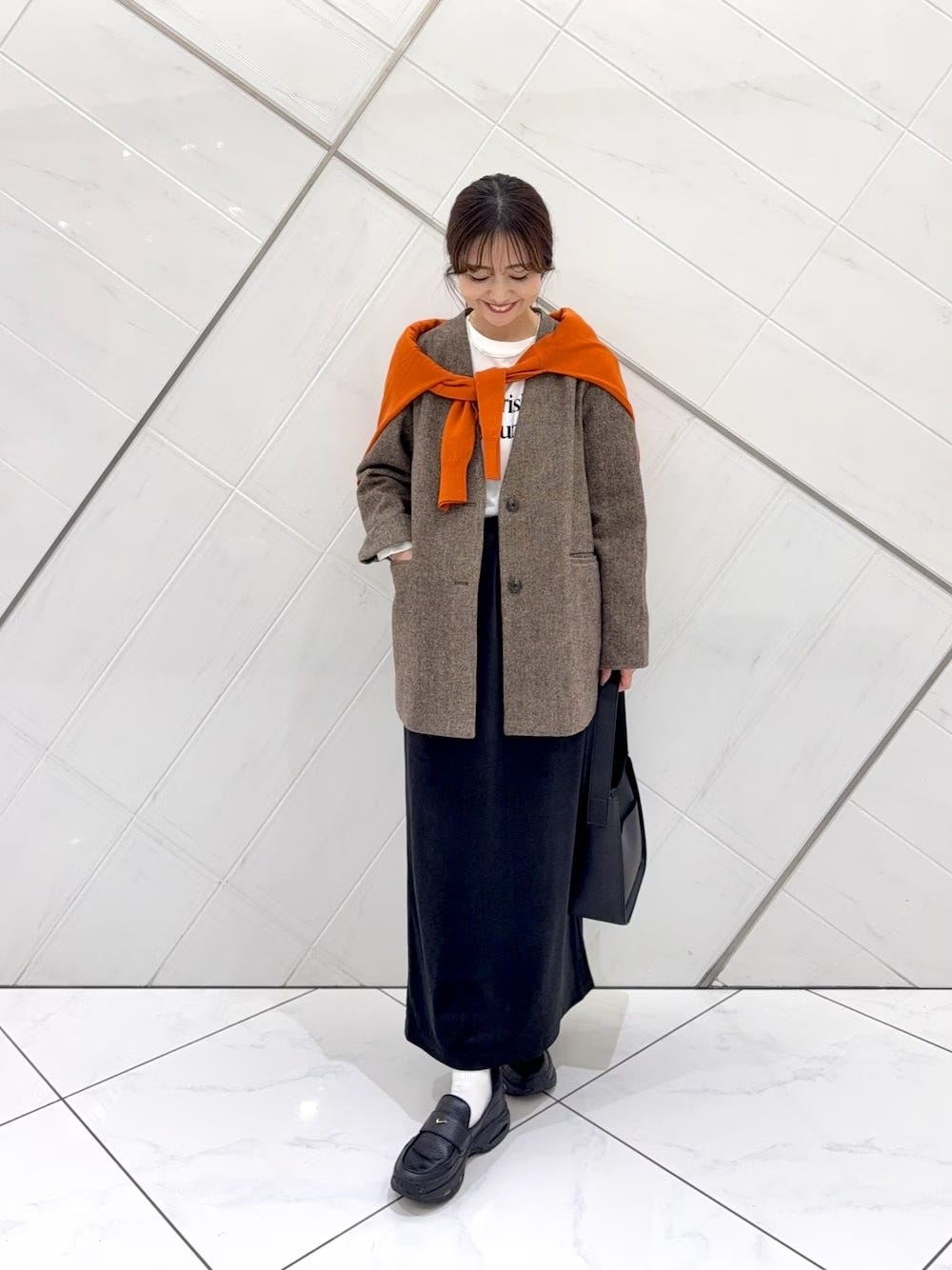 ツイードジャケット×オレンジニットの肩巻きがアクセントに 出典:WEAR