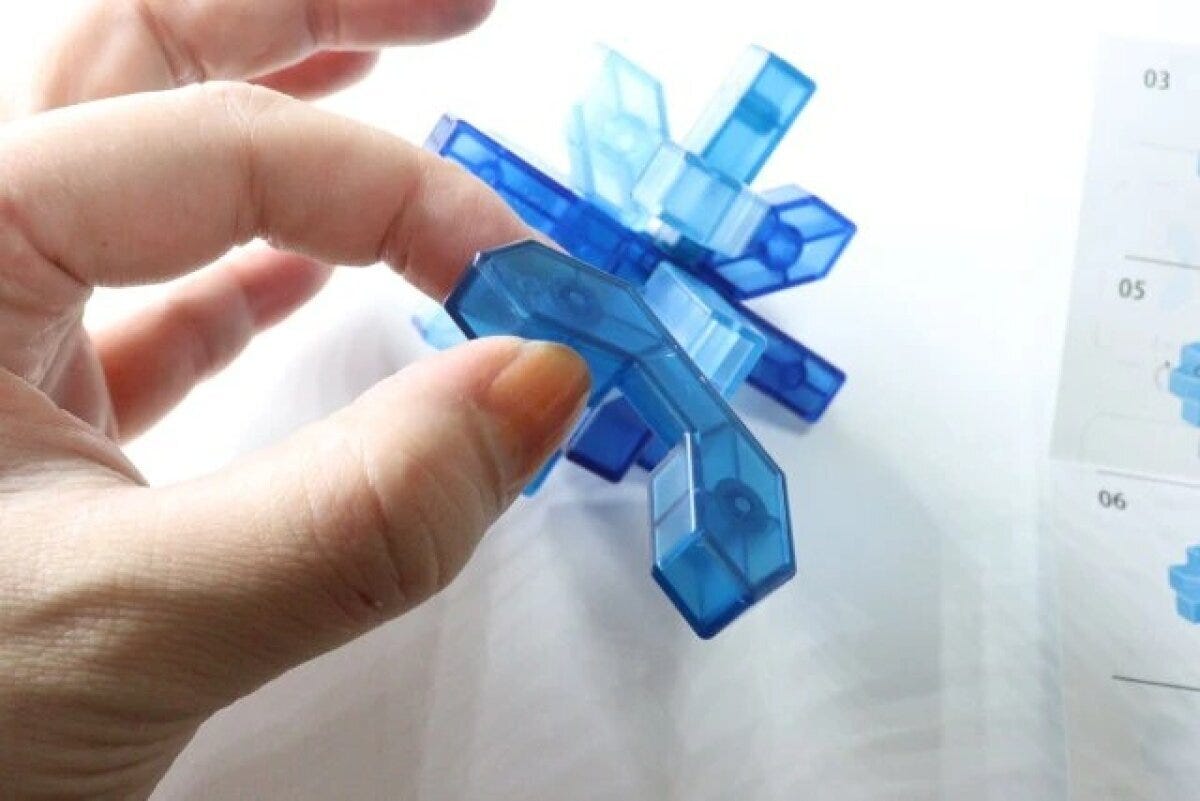 手が青い立体知育パズルを組み立てる様子 手が青い立体知育パズルを組み立てる様子