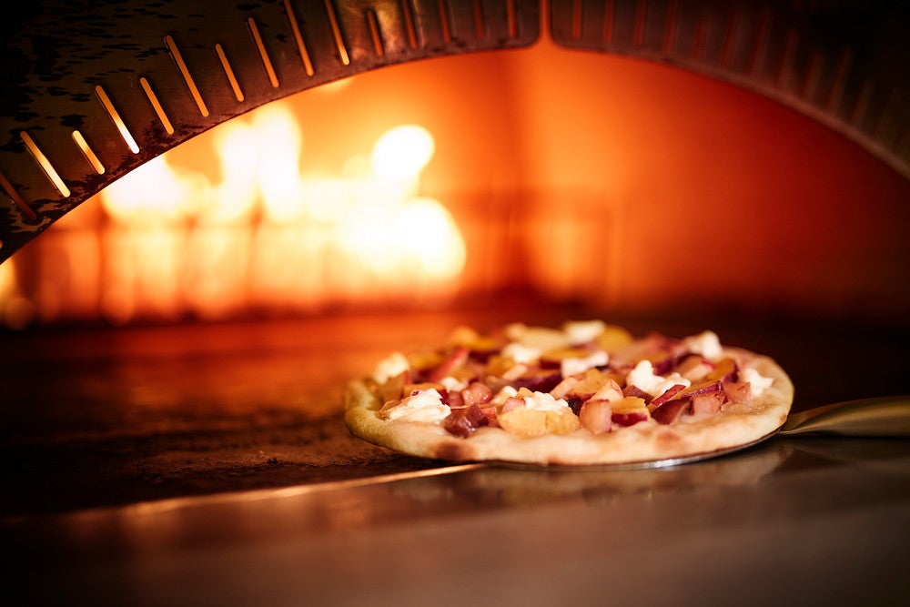 石窯で焼き上げるピッツァ（提供画像）