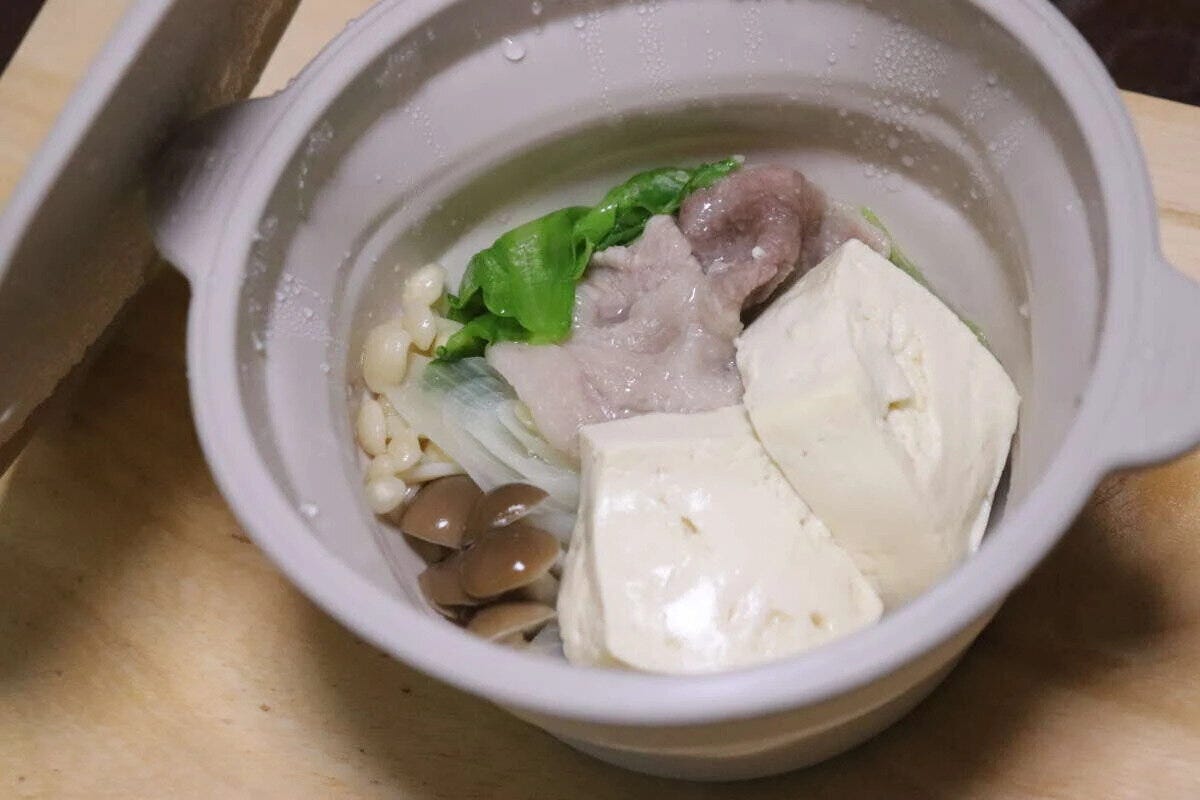 シリコーン小鍋に豚肉、豆腐、きのこ、葉物野菜が入れられている シリコーン小鍋に豚肉、豆腐、きのこ、葉物野菜が入れられている