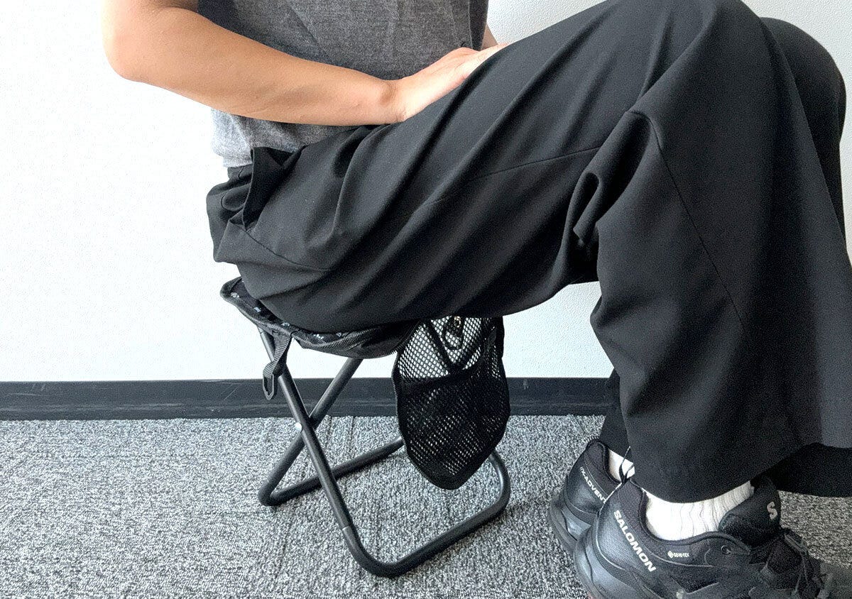 黒いパンツを履いた人がモンスターハンターの折りたたみイスに座っている 黒いパンツを履いた人がモンスターハンターの折りたたみイスに座っている