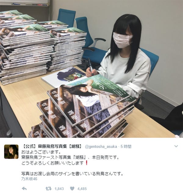 サインを書き入れる齋藤飛鳥/写真集「潮騒」公式Twitterより