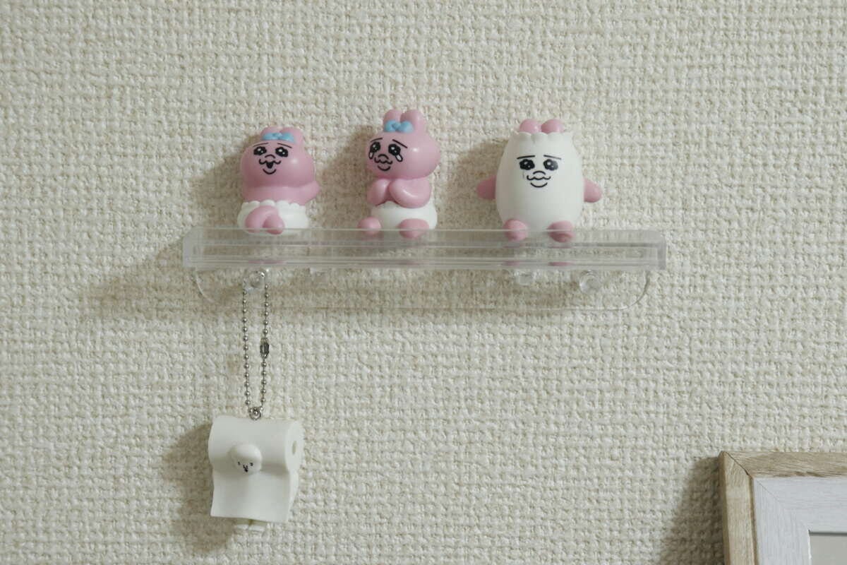 壁に設置されたスタンドに飾られたキャラクターグッズ
