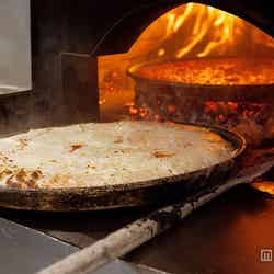 大豆油をふりかけてから火釜へ/画像提供:J-World Diner