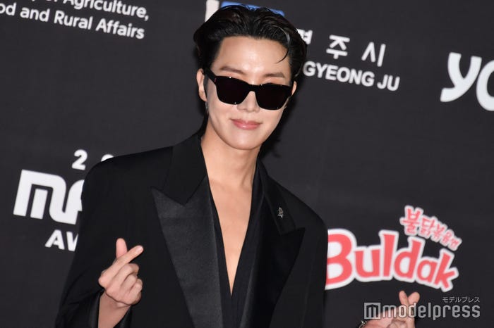 指ハートをして笑顔を見せるJ-HOPE(C)モデルプレス