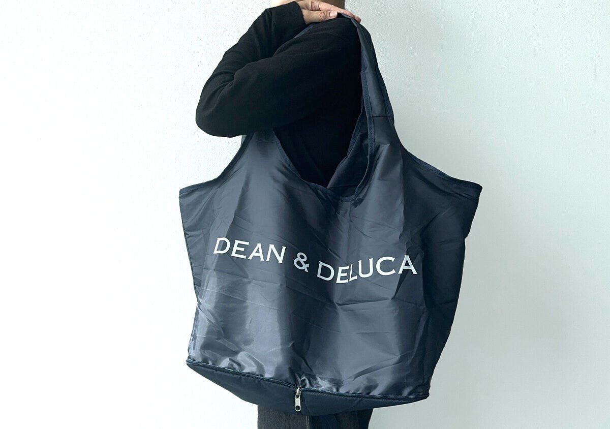黒い服の人がグローサリーバッグを肩掛けしている
