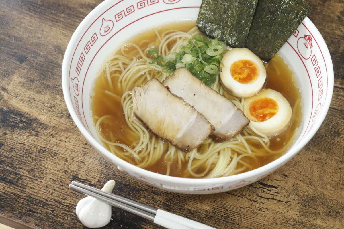 白い器に盛り付けられたラーメン。チャーシュー、煮卵、海苔、ネギがトッピングされている 白い器に盛り付けられたラーメン。チャーシュー、煮卵、海苔、ネギがトッピングされている