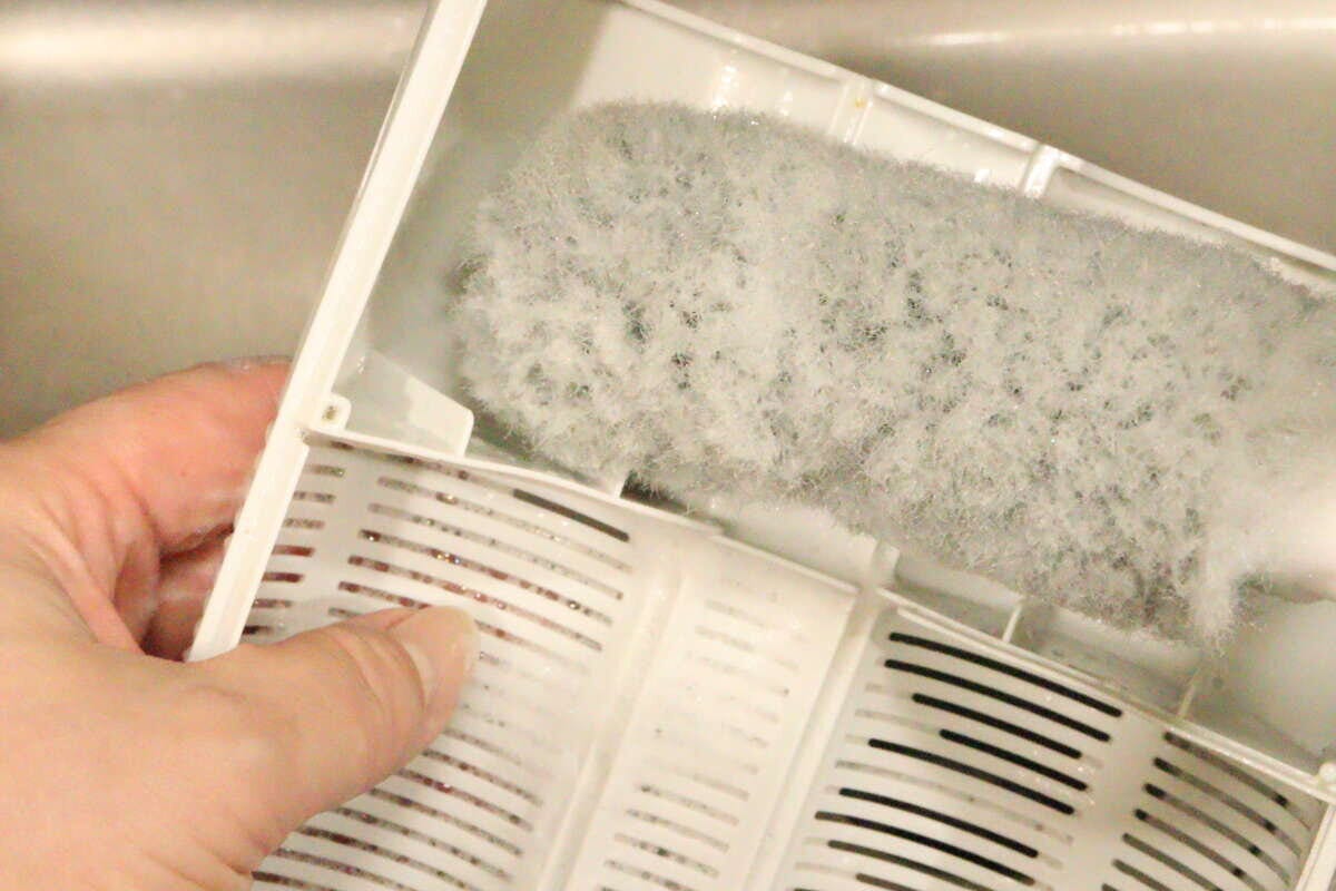排水バスケットクリーナーでキッチンの排水バスケットの底面をこすり洗いしている様子