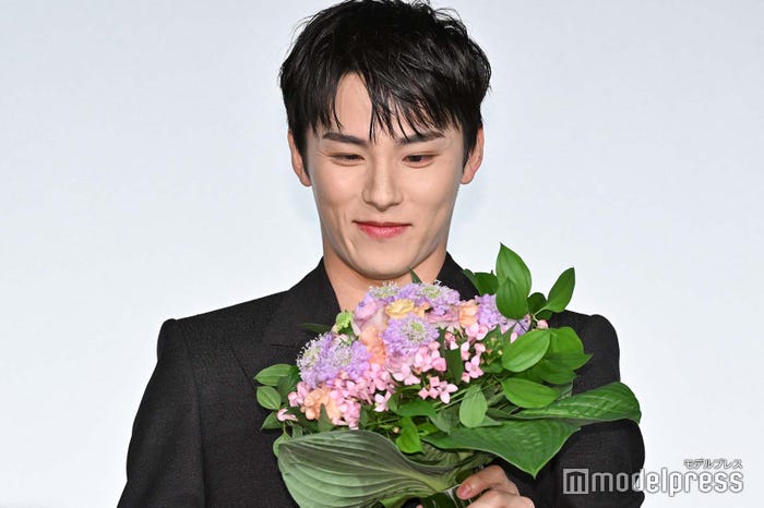 花を見つめる川西拓実(C)モデルプレス