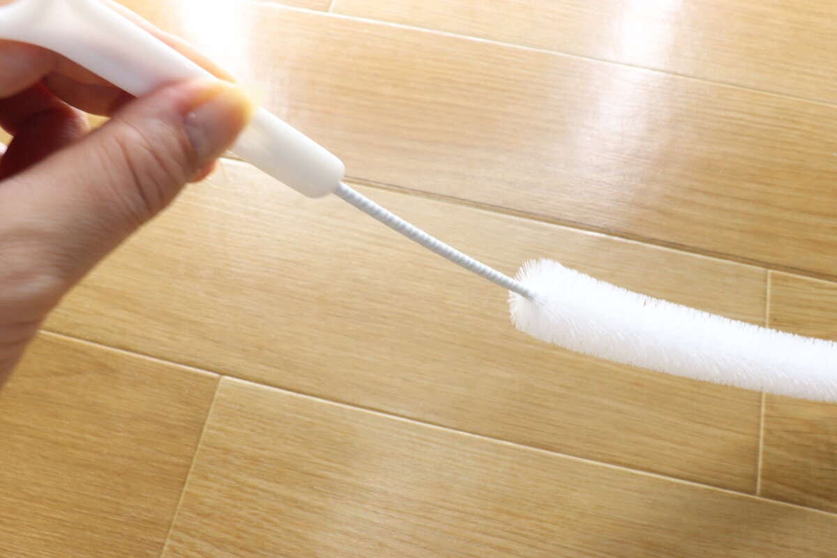 女性の手がパイプクリーナーのブラシ部分をしならせている 女性の手がパイプクリーナーのブラシ部分をしならせている