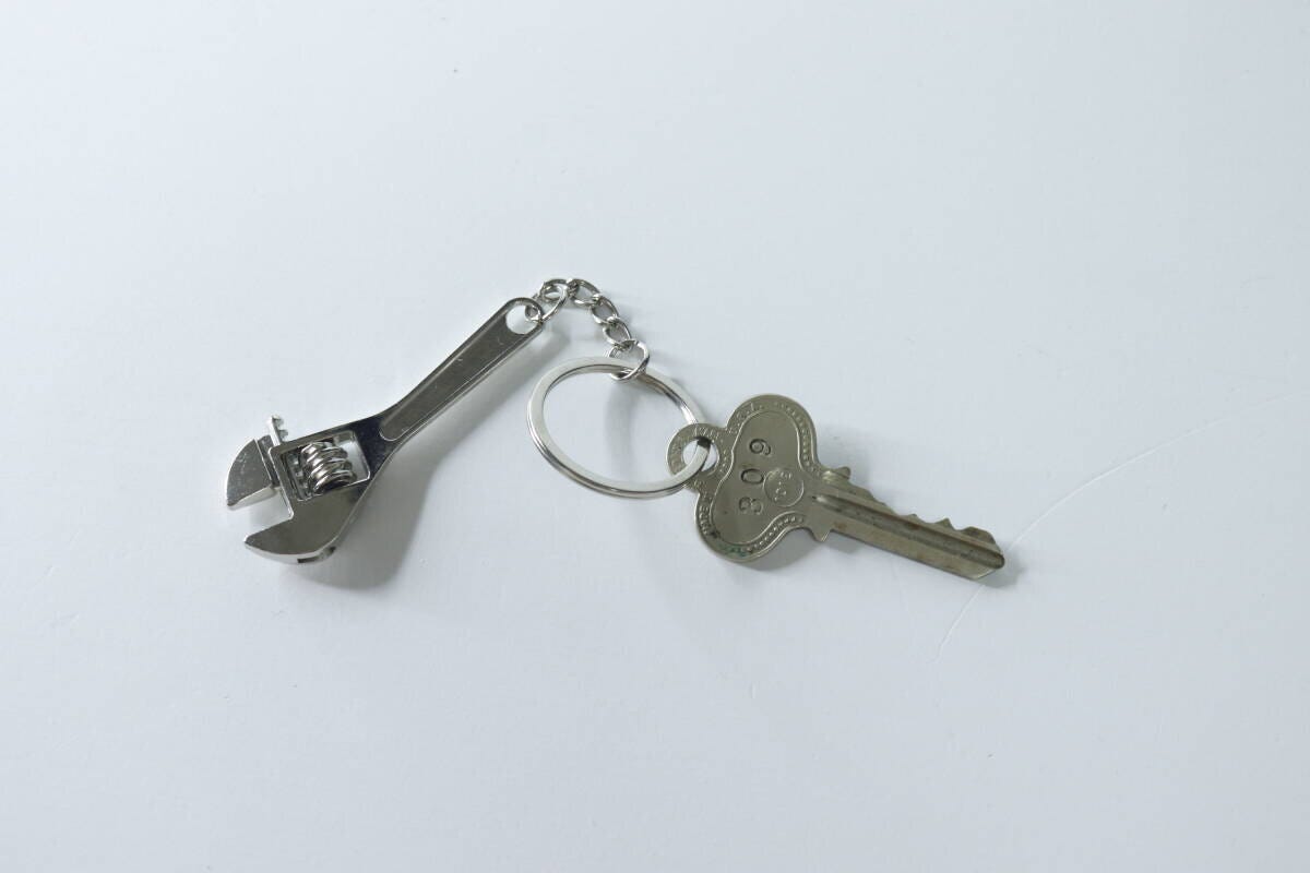 モンキーレンチのキーホルダーと鍵が並べて置かれている