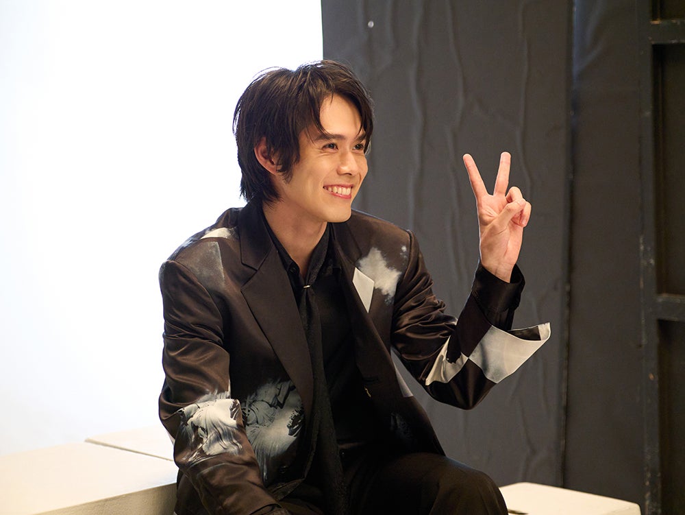 メイキングカメラにピースのポーズで応える細田佳央太／モデルプレス独占カット（提供写真）