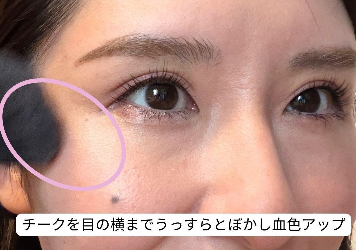 チークを目の横までぼかし血色感をアップさせる様子