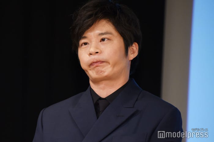 配信カメラに向かって変顔をする田中圭(C)モデルプレス