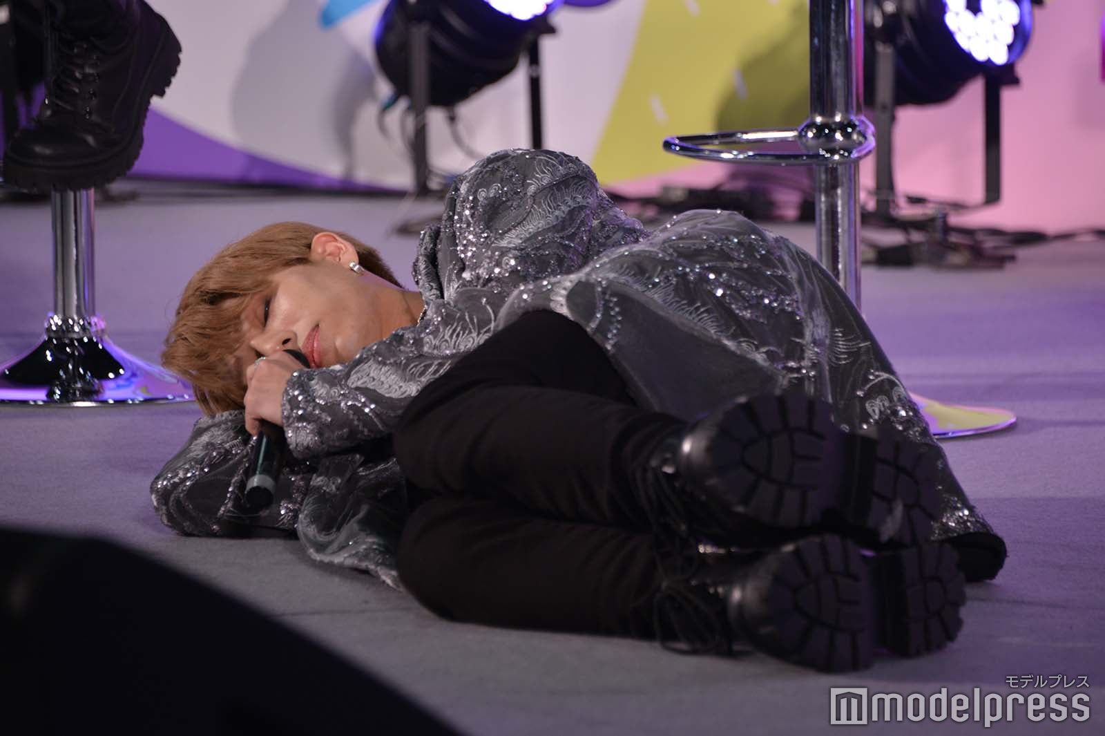 床に寝っ転がる演技でミッションを始める浦野秀太 （C）モデルプレス