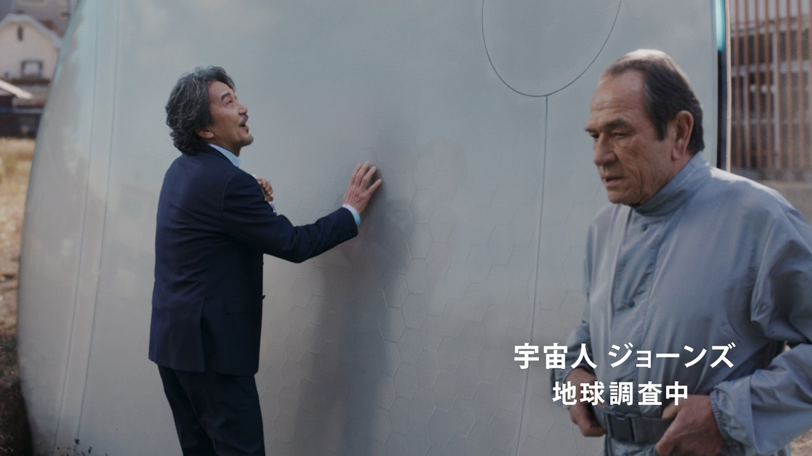 役所広司、トミー・リー・ジョーンズ／新TVCM「町おこし」篇より（提供写真）