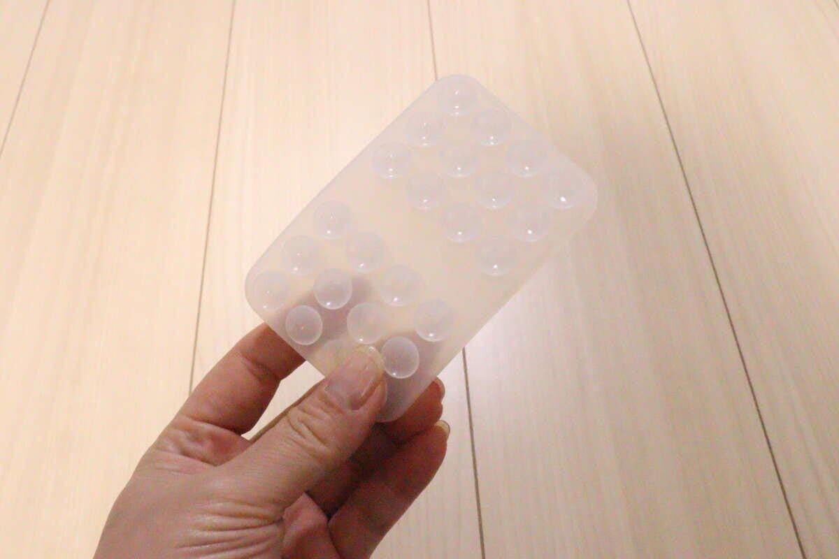 半透明のシリコン携帯吸着マットを手に持っている様子