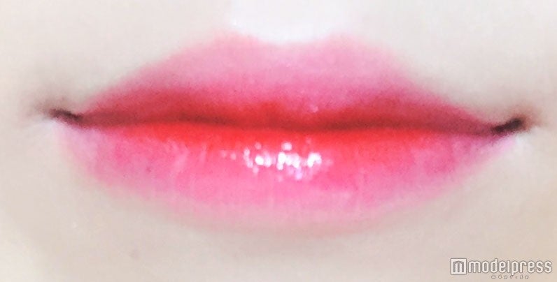 唇の中心に、「ディアダーリンウォータージェルティント“OR203”」を塗る／写真：onoaki（C）モデルプレス