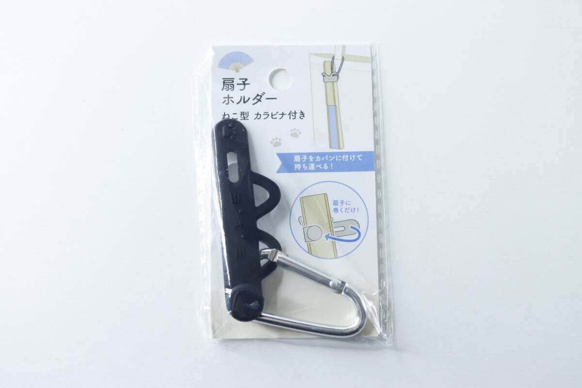 黒いねこ型扇子ホルダーとカラビナが透明なパッケージに入っている
