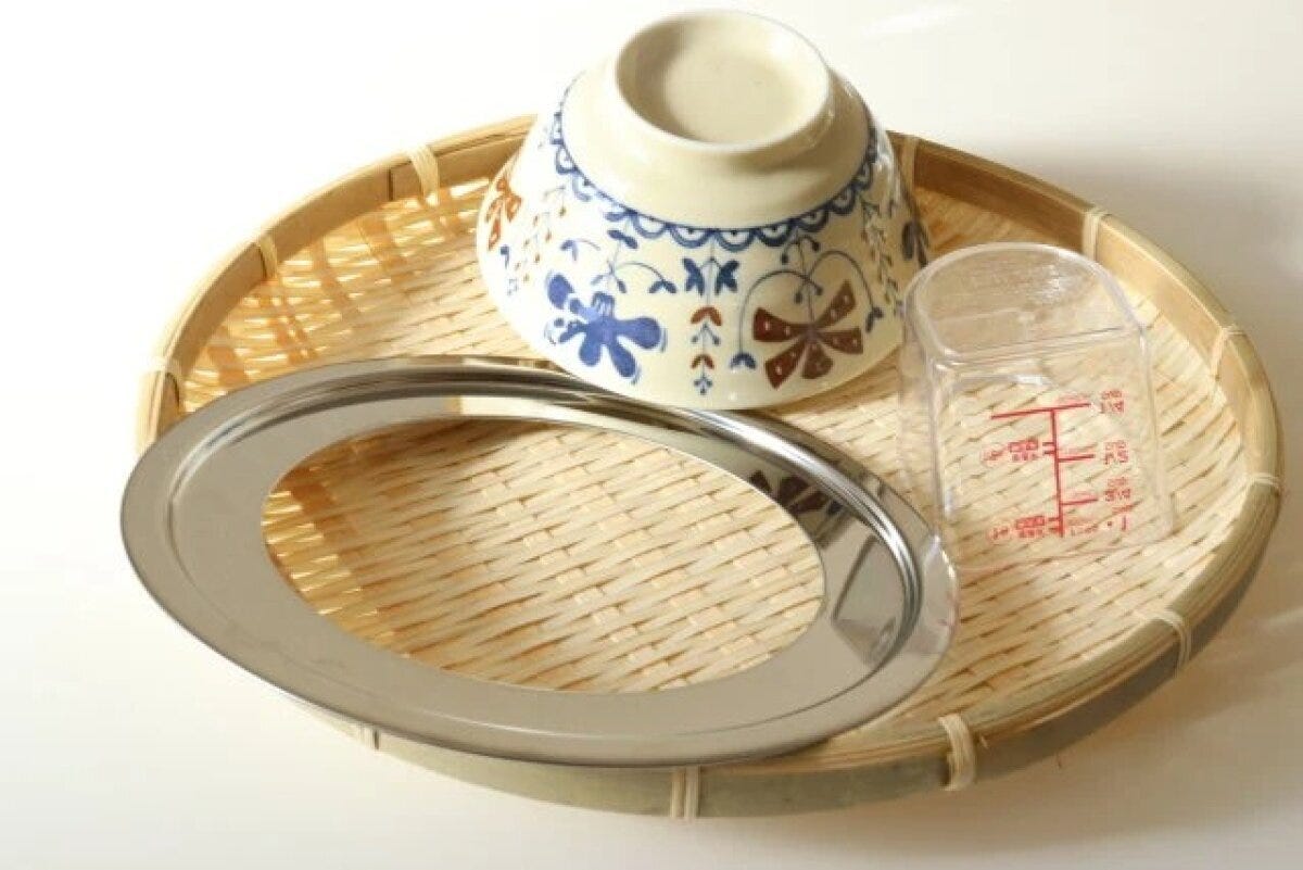 竹ざるの上で食器と計量カップを乾燥させている様子 竹ざるの上で食器と計量カップを乾燥させている様子