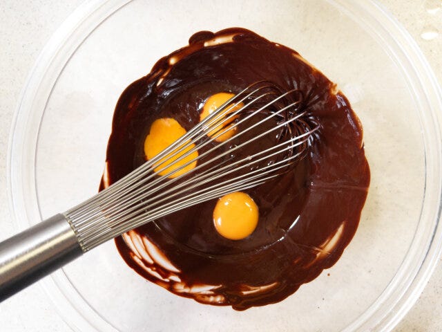 なめらかに溶けたチョコレートに卵黄を加えます。