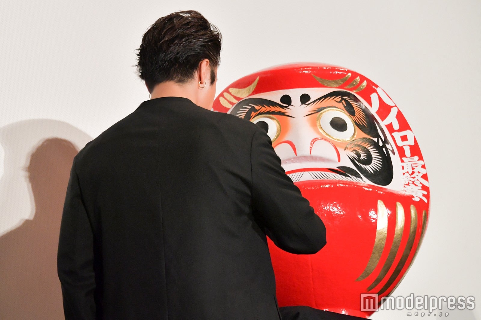 達磨に「大ヒット」の文字を書き込むTAKAHIRO（C）モデルプレス