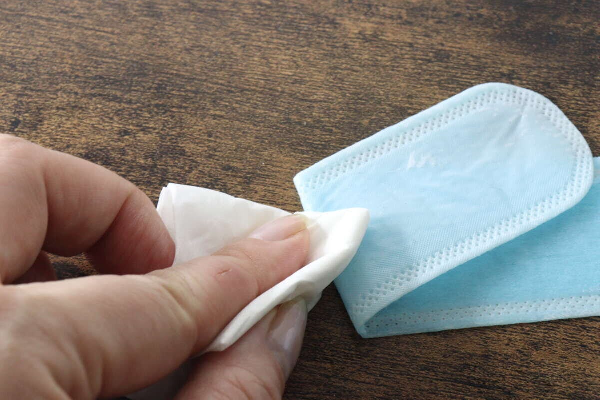 青い液体を吸った汗取りパットの裏側をティッシュで拭いている