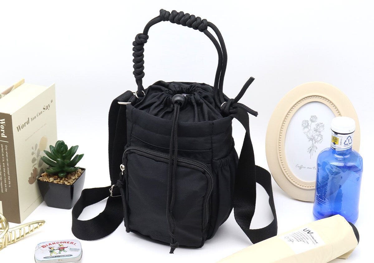 黒いショルダーバッグと本や観葉植物などを並べたスタイリングカット