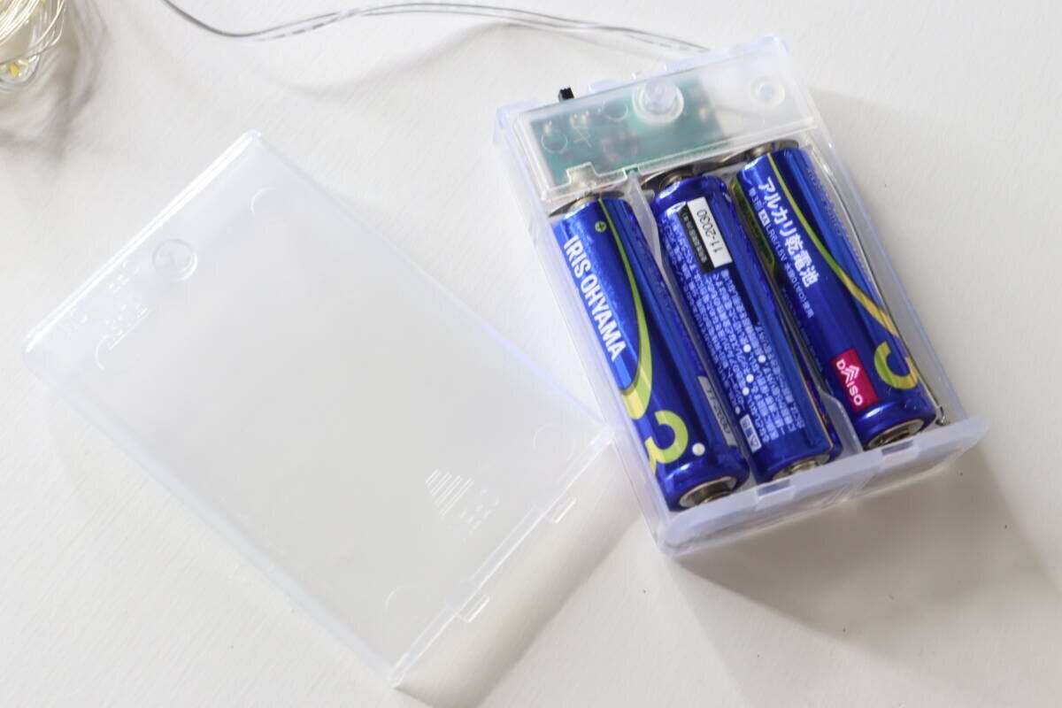 ストリングライトの電池ボックスに単3形乾電池3本を入れている様子。 ストリングライトの電池ボックスに単3形乾電池3本を入れている様子。