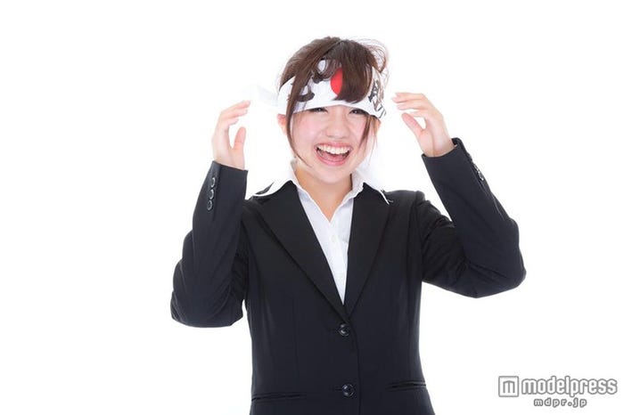 「応援しすぎて必勝ハチマキがゆるむ女子社員」写真素材ぱくたそ/モデル 河村友歌