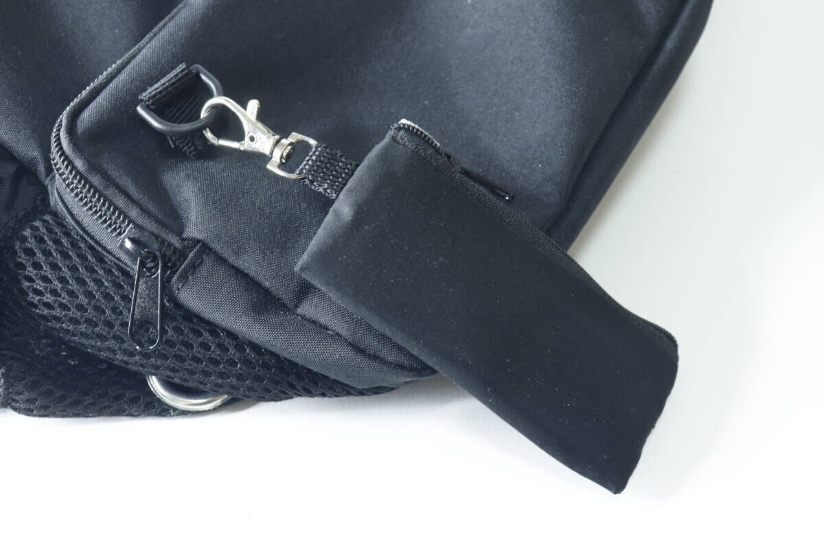 黒いバッグのDカンに、黒いミニポーチがフックで取り付けられている。