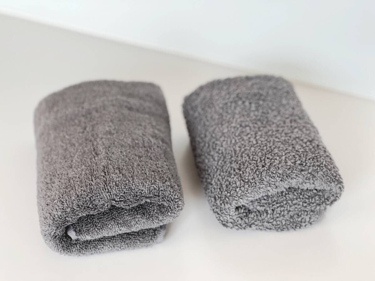 グレーのタオル2枚が折りたたまれて棚の上に並べられた様子