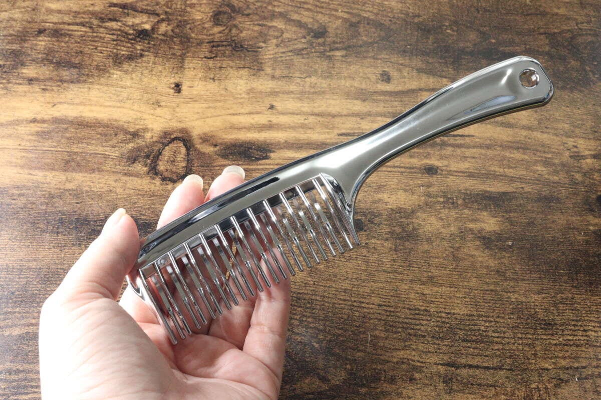 女性の手のひらに乗せられたメタリックなスムースコーム