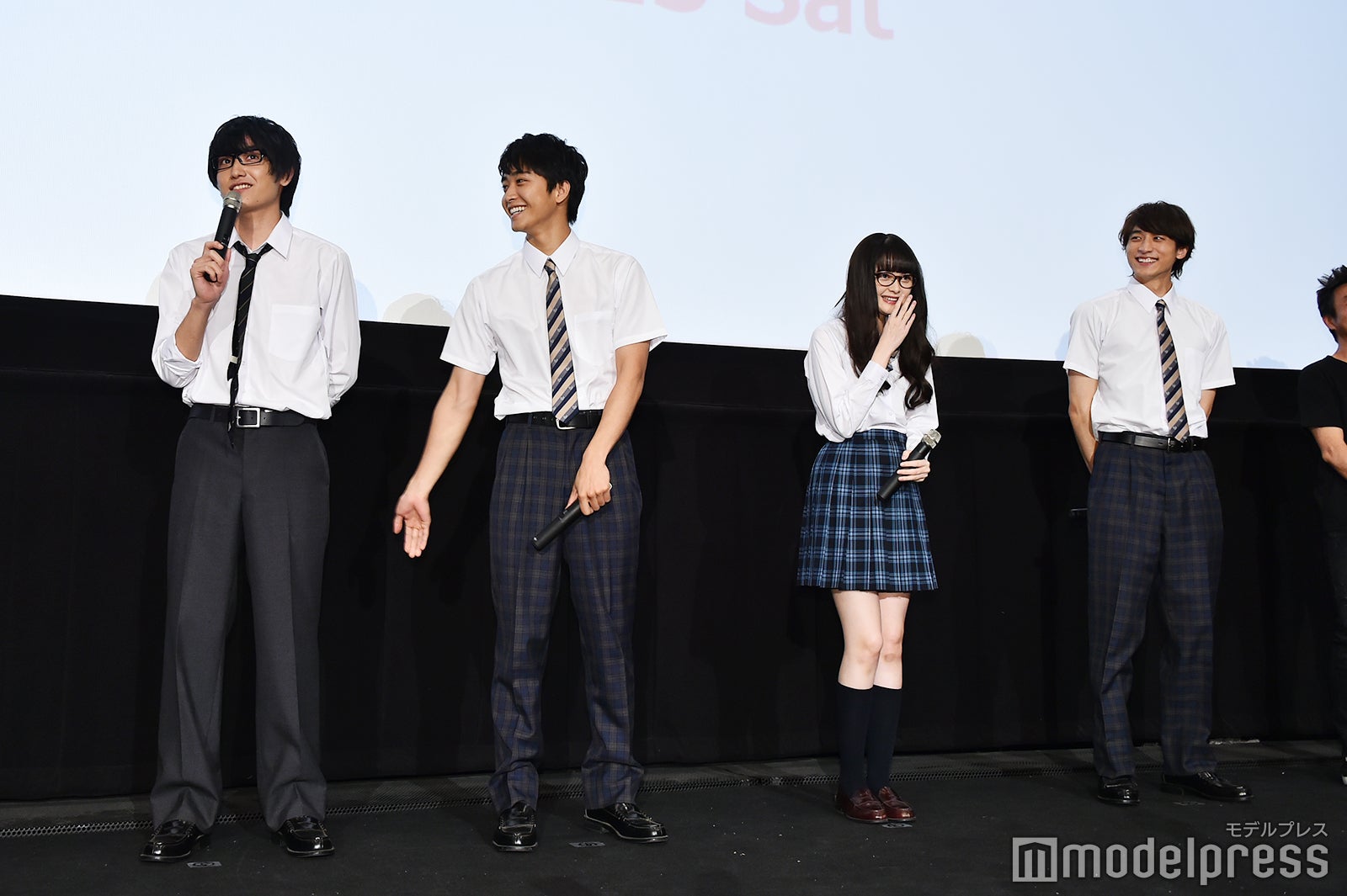 緊張のあまり床を見つめてしまう金子大地のお尻を2回たたく佐藤寛太 （C）モデルプレス