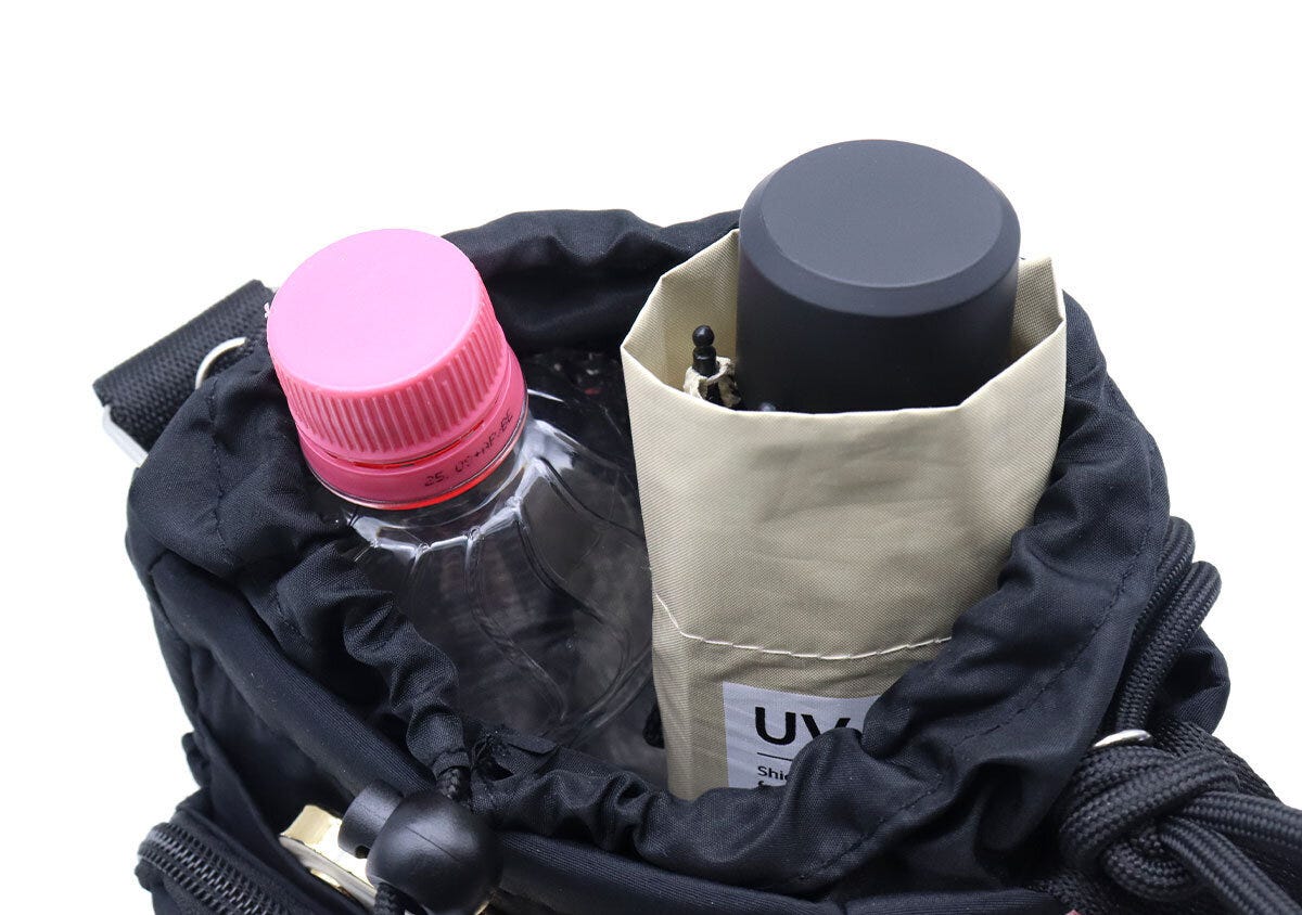 ショルダーバッグの中に500mlペットボトルと折りたたみ傘を立てて収納している様子