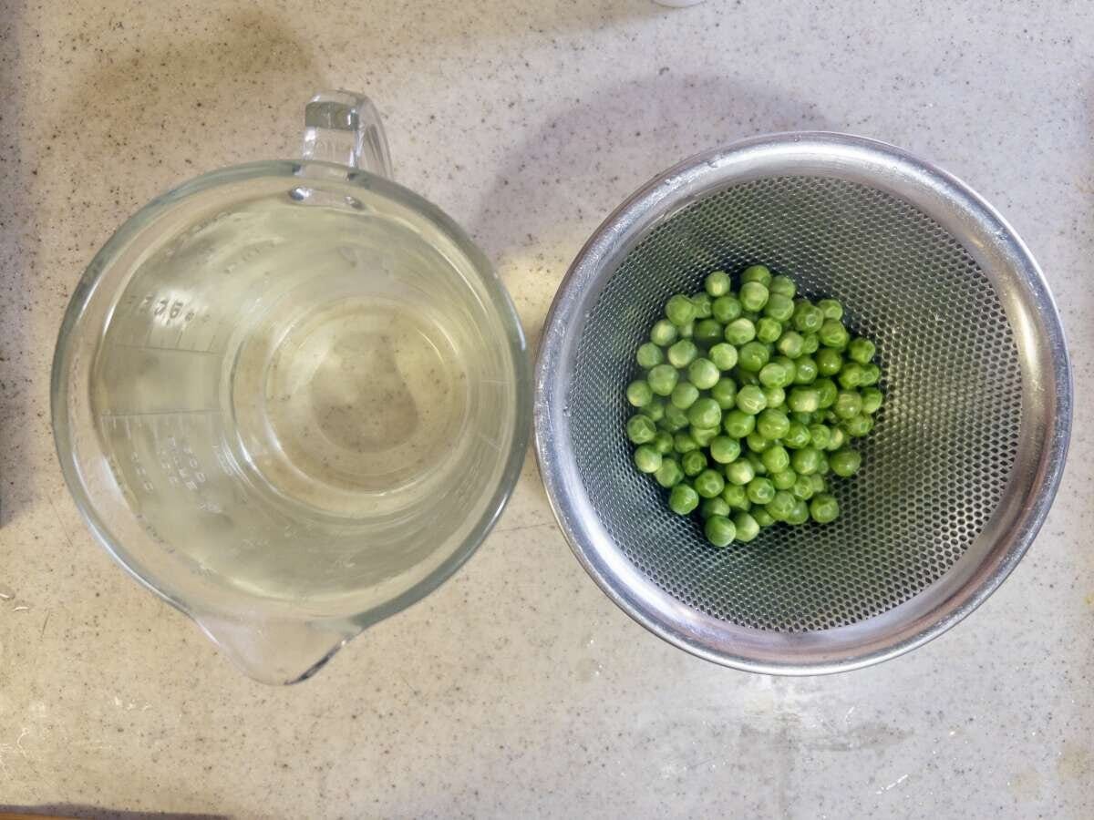茹で上がったグリーンピースと取り置いた茹で汁の計量カップ
