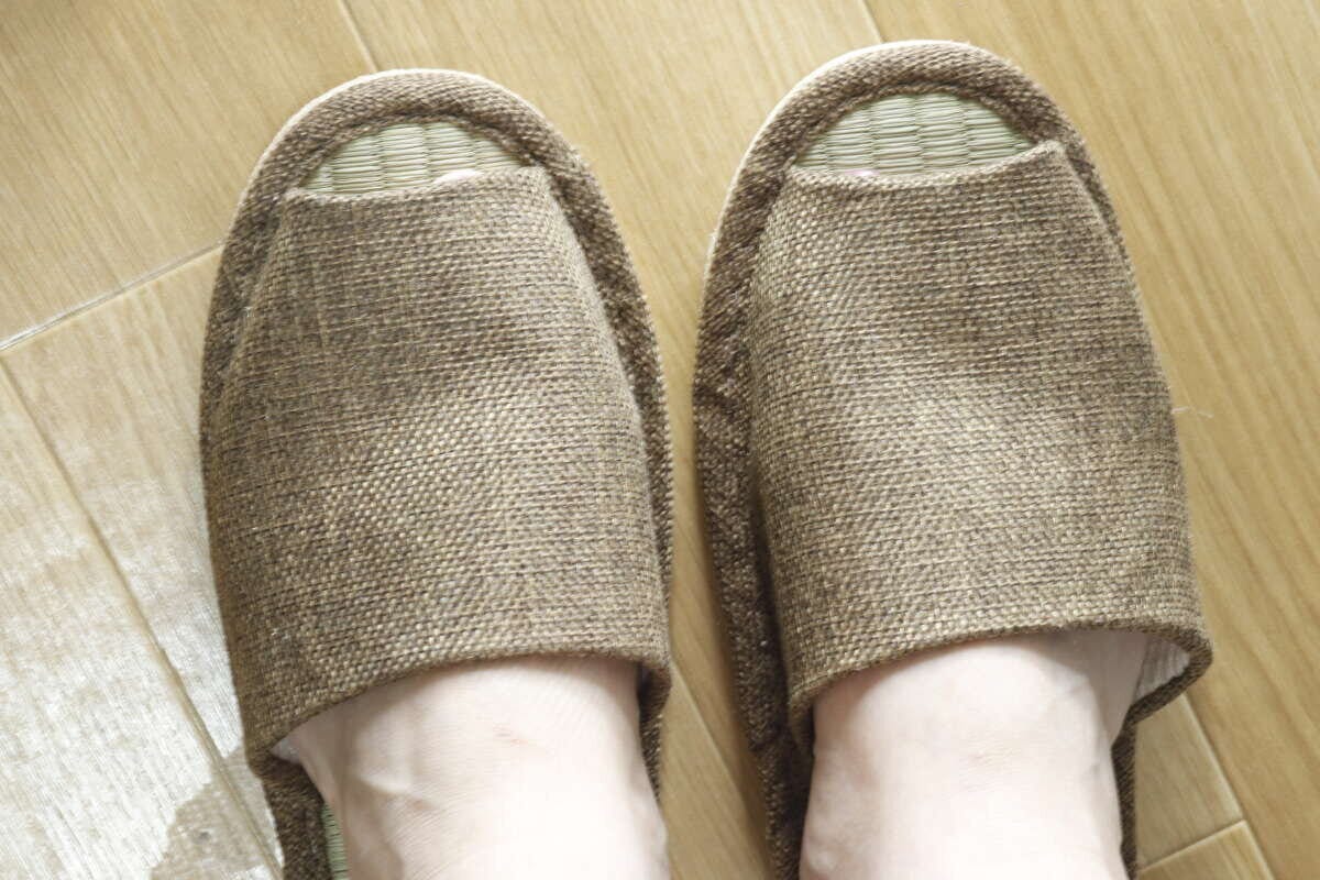 フローリングの上で、い草スリッパを素足で履いている足元 フローリングの上で、い草スリッパを素足で履いている足元