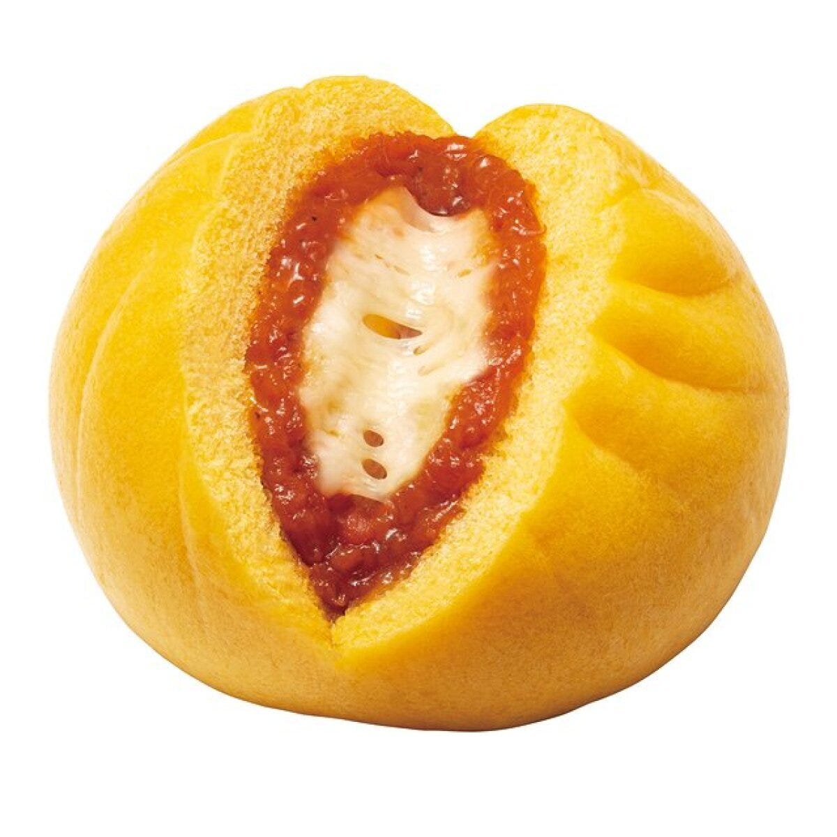 黄色いピザまんの断面からトマトソースと伸びるチーズ 黄色いピザまんの断面からトマトソースと伸びるチーズ