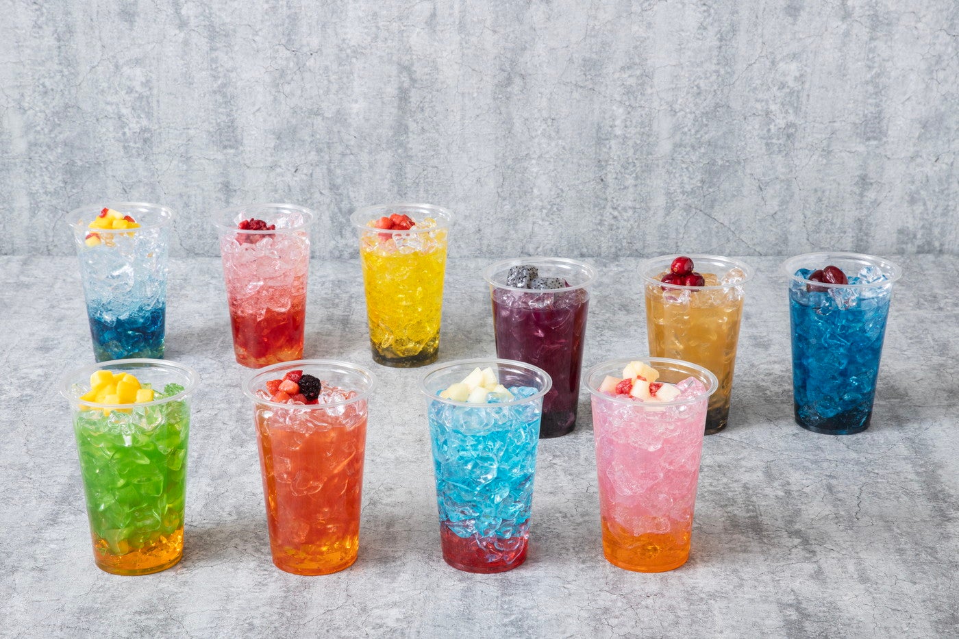 （最奥左から）オールマイトのブルーハワイソーダ／エンデヴァーのトロピカルソーダ／ホークスのレモンスカッシュ<br>
（真ん中左から）死柄木弔のバイオレットピーチドリンク／トガヒミコのアップルジンジャー／荼毘のブルーソーダ<br>
（手前左から）緑谷出久のメロングリーンティー／爆豪勝己のマンゴードリンク／轟焦凍のブルーラムネドリンク／麗日お茶子のピーチ<br>
スカッシュ各990円（税込） ※画像はイメージ（C）堀越耕平／集英社