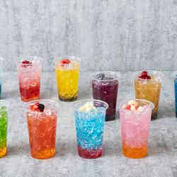 (最奥左から)オールマイトのブルーハワイソーダ/エンデヴァーのトロピカルソーダ/ホークスのレモンスカッシュ
(真ん中左から)死柄木弔のバイオレットピーチドリンク/トガヒミコのアップルジンジャー/荼毘のブルーソーダ
(手前左から)緑谷出久のメロングリーンティー/爆豪勝己のマンゴードリンク/轟焦凍のブルーラムネドリンク/麗日お茶子のピーチ
スカッシュ各990円(税込) ※画像はイメージ(C)堀越耕平/集英社