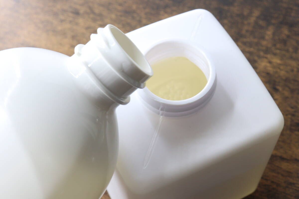 ワンプッシュディスペンサーボトルに洗剤を注ぎ入れている